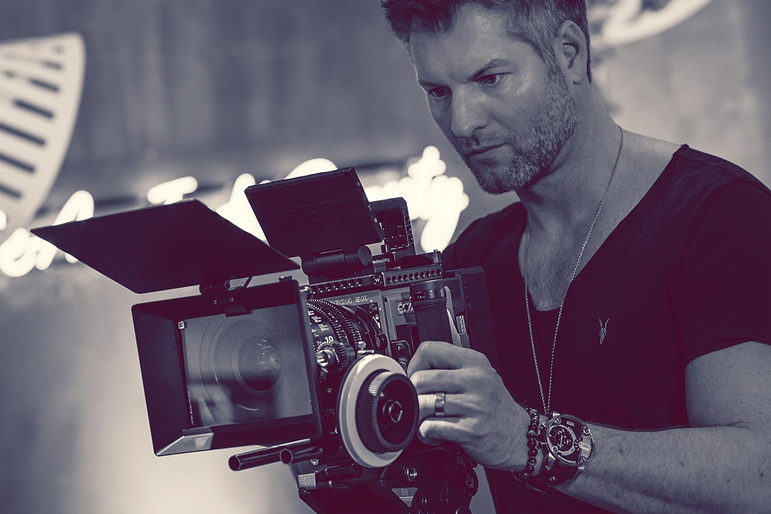 Kyle Cassie behind a cinema camera, black and white portrait